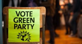 A photo of the back of a chair with a poster attached reading 'vote Green Party'