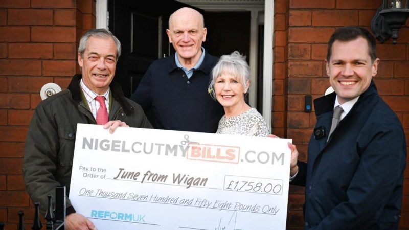 Nigel Farage posing with the winners of his energy bill giveaway